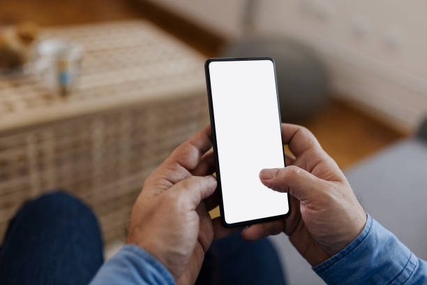 istock Phone With Blank White Screen in Man Hand at Home 1920393695