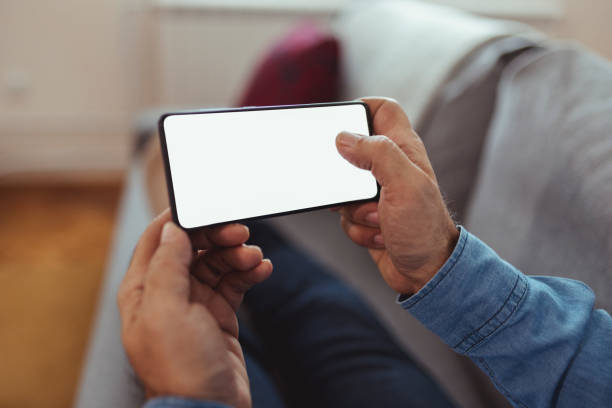 istock Phone With Blank White Screen in Man Hand at Home 1920393696