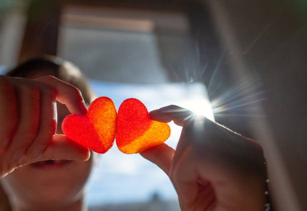 Little boy with heart-shaped sweets in hands.