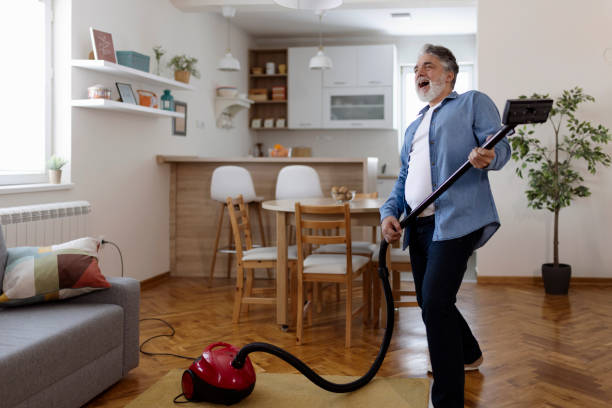 istock Bearded Mature Man Dancing Happily With a Vacuum Cleaner 1920395319