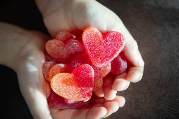 Little boy with heart-shaped sweets in hands.