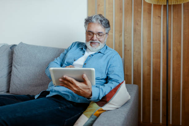 istock Mature Adult Man Using Digital Tablet at Home 1920400541