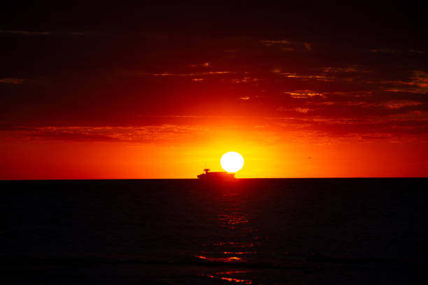 Beautiful orange sunset over the sea, a ship on the horizon