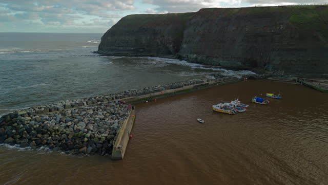 Establishing Drone Shot of Staithes Harbour Out to Sea Yorkshire UK