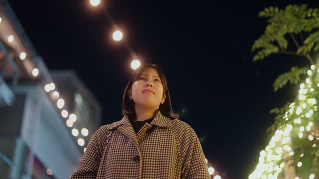 Woman walking in city decorated with Christmas lights in Tokyo