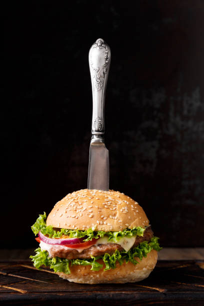 istock Burger with beef on a dark background, in a hamburger vintage knife. 1920474234