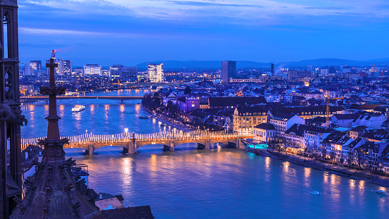 Night cityscape of the Swiss city Basel over the Rhine river with Christmas street lights on the Middle Bridge, viewed from the Minster Church tower.