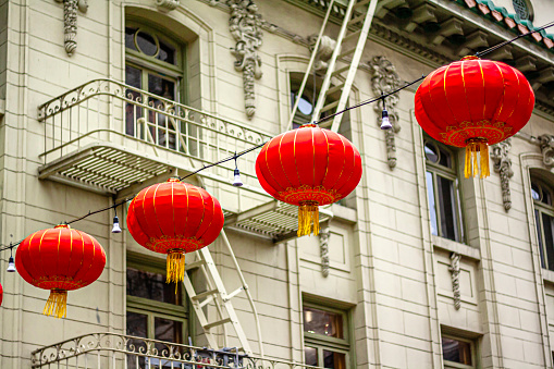 Red lanterns hanging in front of a green building in Chinatown in San Francisco, California