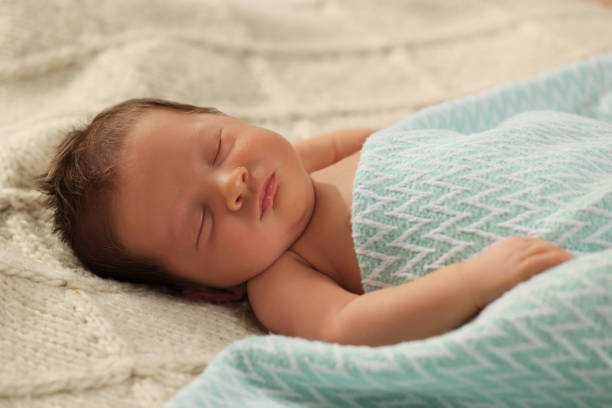 The little baby is exercising in bed