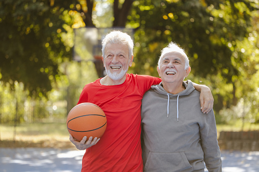 Photo of two active senior men on the basketball court