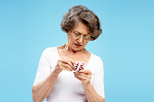 ernste-seniorin-mit-brille-und-blase-mit