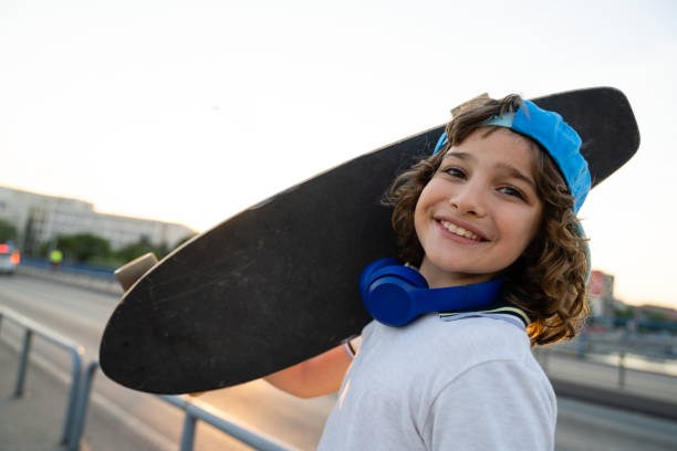 istock Happy skater boy carrying a skateboard on his shoulder 1920622691