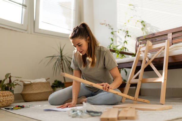 istock Young woman reads the instructions for assembling furniture 1920643930