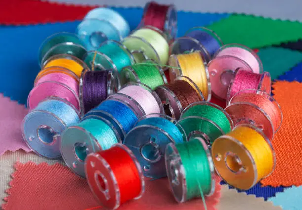 Photo of Plastic bobbins for a sewing machine with multi-colored threads.
