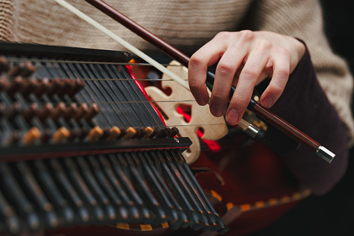 Skillful hands maneuver the Nyckelharpa's keys and strings, a testament to the enduring legacy of folk music