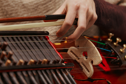 Nyckelharpa, with its resonant strings and unique keys, held by a performer deeply connected to heritage music