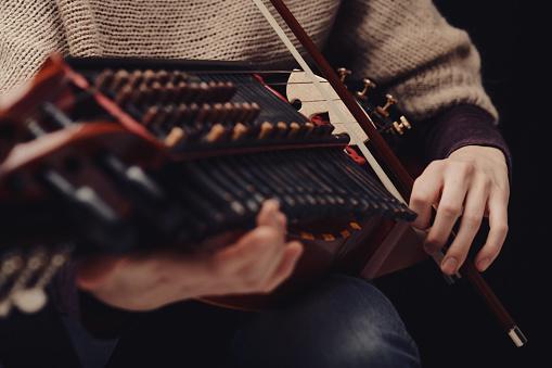 Close-up of a Nyckelharpa, an intricately crafted traditional Swedish instrument, played by a dedicated musician
