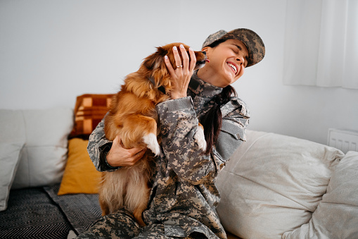 Female Soldier with her dog sitting on a sofa
