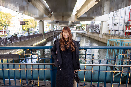 Portrait of woman standing on bridge under the expressway