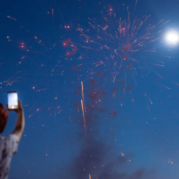 istock Celebratory fireworks against the blue evening sky. Yellow glow on a dark blue background. 1920778098