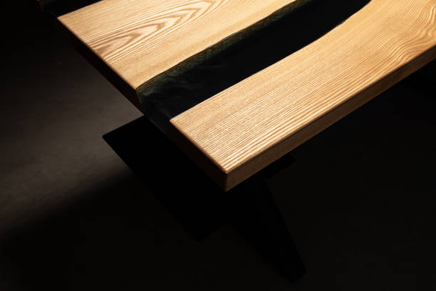 istock The table is covered with epoxy resin and varnished. Luxury quality wood processing. Wooden table on a dark background. Black river made of epoxy resin. 1920789798