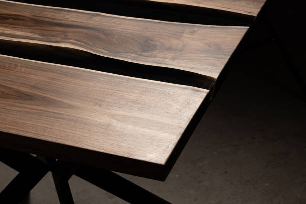 istock The table is covered with epoxy resin and varnished. Luxury quality wood processing. Wooden table on a dark background. Business proposal concept. 1920803079