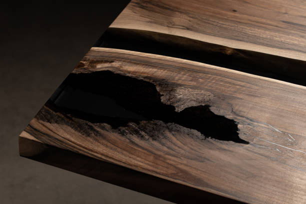 istock The table is covered with epoxy resin and varnished. Luxury quality wood processing. Wooden table on a dark background. Business proposal concept. 1920804111