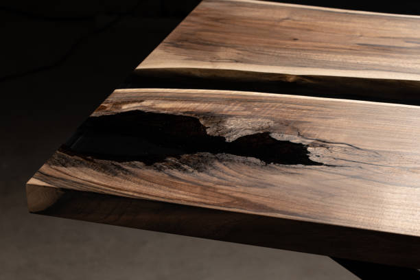 istock The table is covered with epoxy resin and varnished. Luxury quality wood processing. Wooden table on a dark background. Business proposal concept. 1920804114