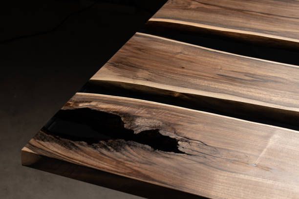 istock The table is covered with epoxy resin and varnished. Luxury quality wood processing. Wooden table on a dark background. Business proposal concept. 1920804117