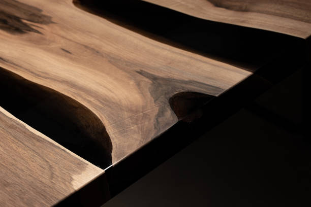 istock The table is covered with epoxy resin and varnished. Luxury quality wood processing. Wooden table on a dark background. Business proposal concept. 1920805659
