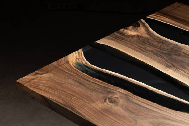 istock The table is covered with epoxy resin and varnished. Luxury quality wood processing. Wooden table on a dark background. Business proposal concept. 1920821221