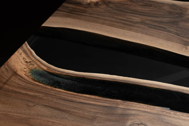 istock The table is covered with epoxy resin and varnished. Luxury quality wood processing. Wooden table on a dark background. Business proposal concept. 1920821224