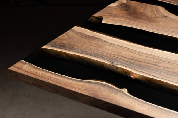 istock The table is covered with epoxy resin and varnished. Luxury quality wood processing. Wooden table on a dark background. Business proposal concept. 1920824808