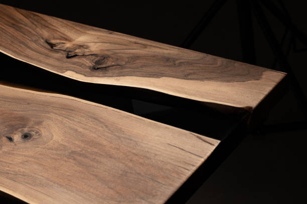 istock The table is covered with epoxy resin and varnished. Luxury quality wood processing. Wooden table on a dark background. Business proposal concept. 1920824810