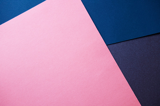 Color papers background with light and dark blue and pink tones