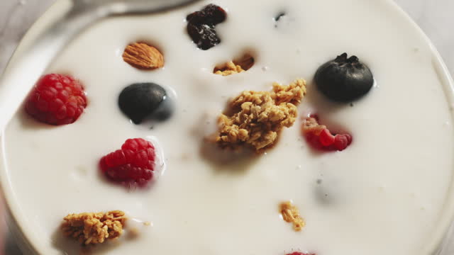 Vanilla yogurt with granola and blueberries whit spoon