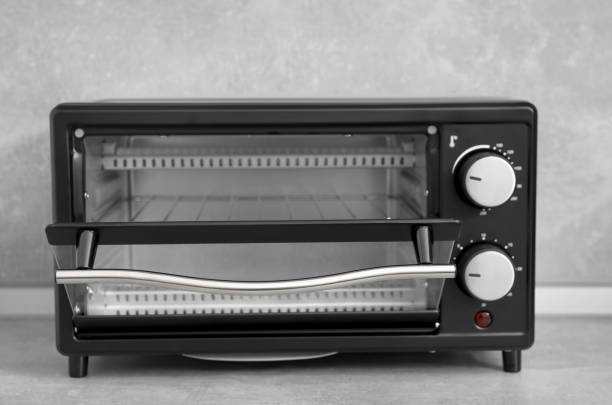 istock One electric oven on light grey table, closeup. Cooking appliance 1920899694