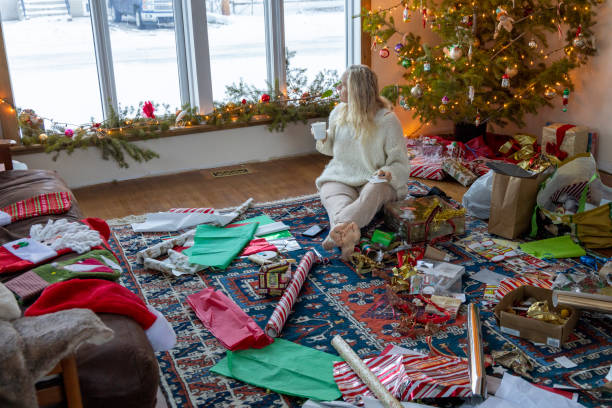 istock Woman wraps Christmas presents under Christmas tree 1920902997