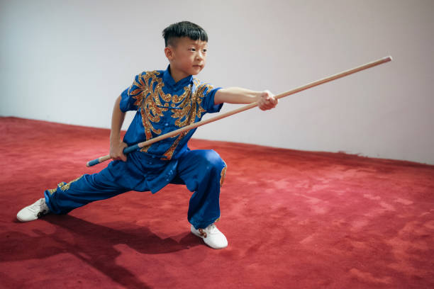 Young chinese boy practising Wushu in a gym