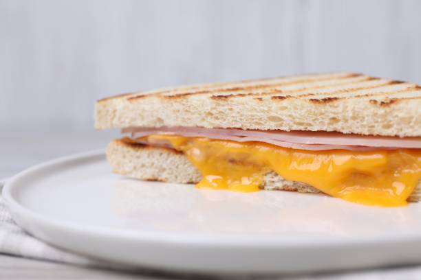 istock Delicious grilled sandwich with ham and cheese on table, closeup 1920910121