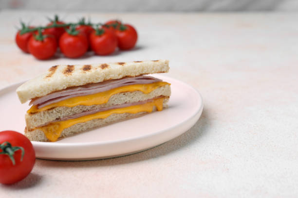 istock Delicious grilled sandwich with ham, cheese and tomatoes on white table, space for text 1920916568