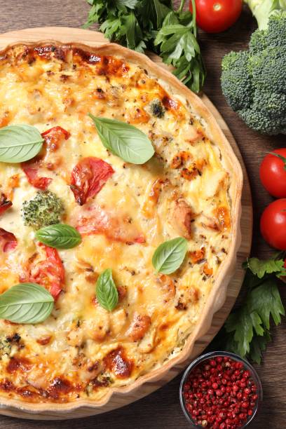 istock Tasty cheese quiche and ingredients on wooden table, flat lay 1920922376