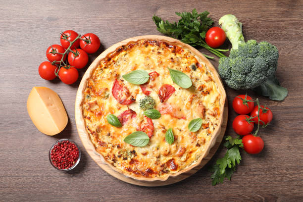 istock Tasty cheese quiche and ingredients on wooden table, flat lay 1920924531