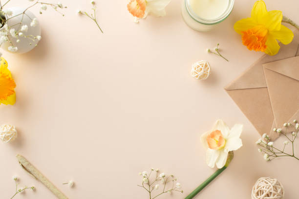 istock Extend your heartfelt spring wishes with daffodils and gypsophila. Top view image captures flowers, an envelope, aroma candle and decor on a serene beige isolated background, ready for adverts or text 1920924559