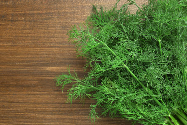 istock Fresh green dill on wooden table, top view. Space for text 1920925079