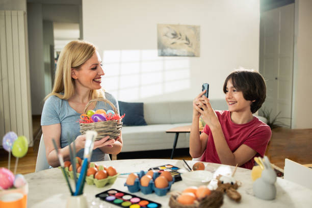 istock Boy taking a photo of his mom with Easter eggs 1920938279