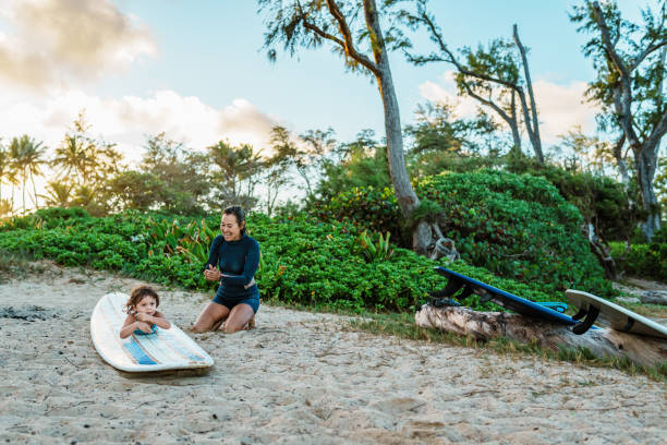 istock Toddler lays on surfboard while learning how to surf 1920940864