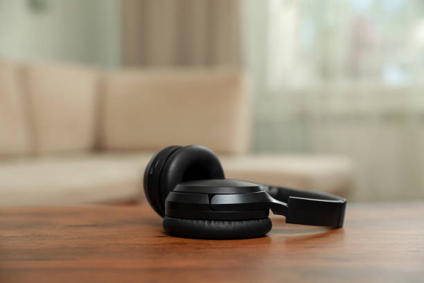 istock Modern wireless headphones on wooden table indoors 1920994645