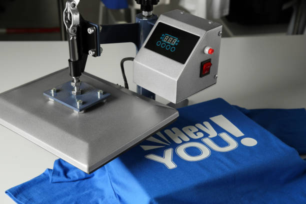 istock Printing logo. Heat press with blue t-shirt on white table, closeup 1920995963