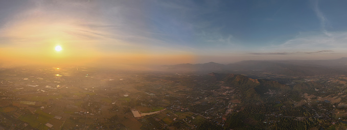 Aerial drone view. High flight in the mountains . Aerial view of a  morning sunrise above dense white clouds with a blue sky overhead.